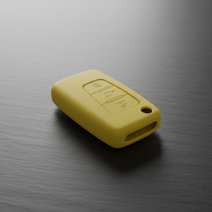 Yellow silicone car key case cover on dark slate surface, studio lighting, top-down 3/4 angle