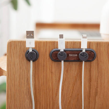 Magnetic cable management clips organizing charging cords on a sleek, minimalist desk setup.