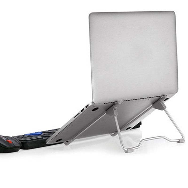 Modern minimalist desk setup featuring an aluminum laptop and phone stand