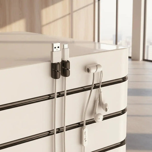 Silicone cable clips organizing USB and charging cables on a clean desk.